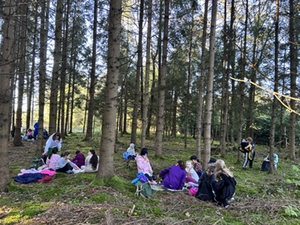 Kinder machen Brotzeit im Wald